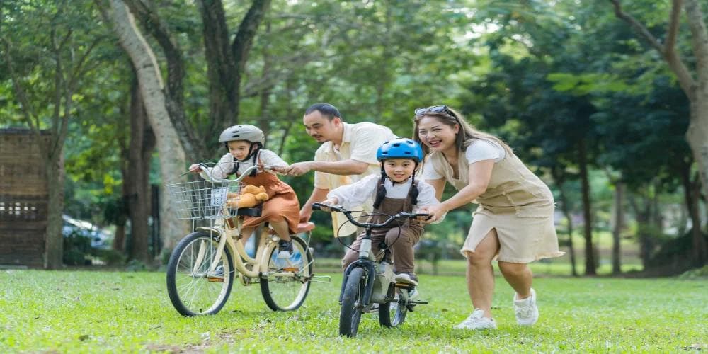 Happy parents teaching children to ride bicycles in a park, symbolising family harmony, support, and guidance connected to Bazi analysis and Chinese baby names.